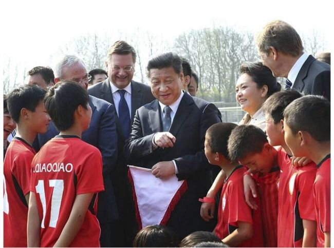 President Xi Jinping and his wife Peng Liyuan visit the Zhidan youth football league members who were training in Germany on March 29, 2014. [Photo: China Plus]
