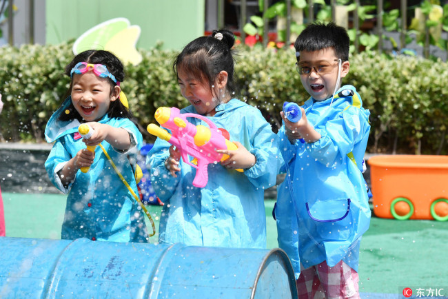 Kindergarten kids play with water pistols during celebrations for the upcoming Children's Day in Huai'an, Jiangsu Province, Wednesday, May 30, 2018. [Photo: VCG]