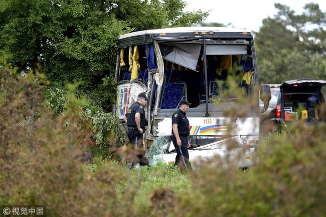 OPP officers work at the site of a crash involving a tour bus on Highway 401 West, near Prescott, Ont. on Monday, June 4, 2018.[Photo: IC]