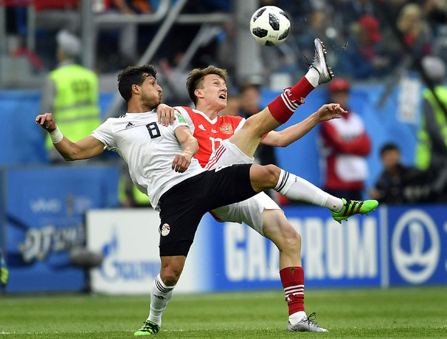 Egypt's Tarek Hamed, left, and Russia's Alexander Golovin compete for the ball during the group A match between Russia and Egypt at the 2018 soccer World Cup in the St. Petersburg stadium in St. Petersburg, Russia, Tuesday, June 19, 2018. [Photo: AP]