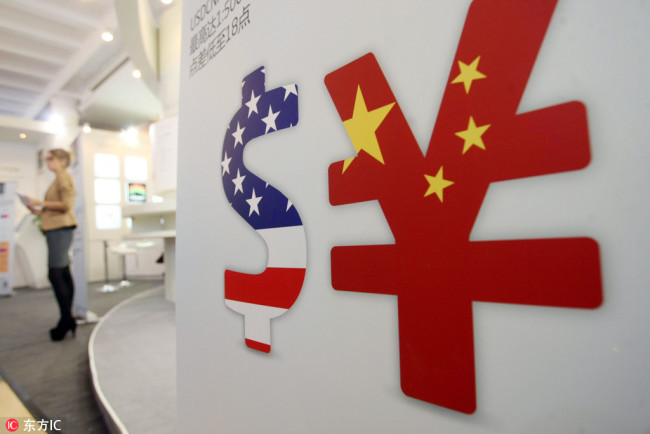 Signs of US dollar (USD) and China yuan (CNY) are seen during an exhibition in Shanghai. [File photo: IC]