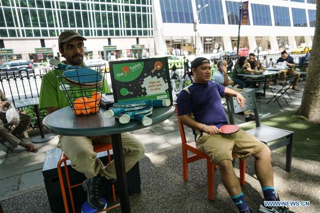 A player (R) waits for his turn to play ping pong at Bryant Park in New York, the United States on June 26, 2018.[Photo: Xinhua/Lin Bilin]