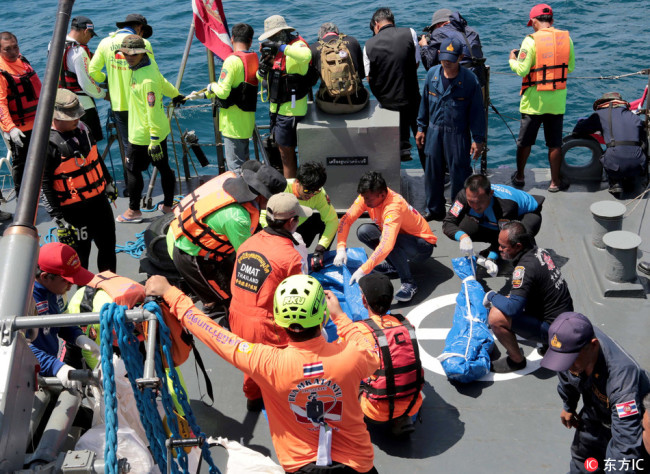 Thai rescue workers carry the body of a tourist aboard a navy vessel after a boat sank, as search and rescue operations continue in the seas off Phuket island, southern Thailand, 07 July 2018.[Photo: IC]