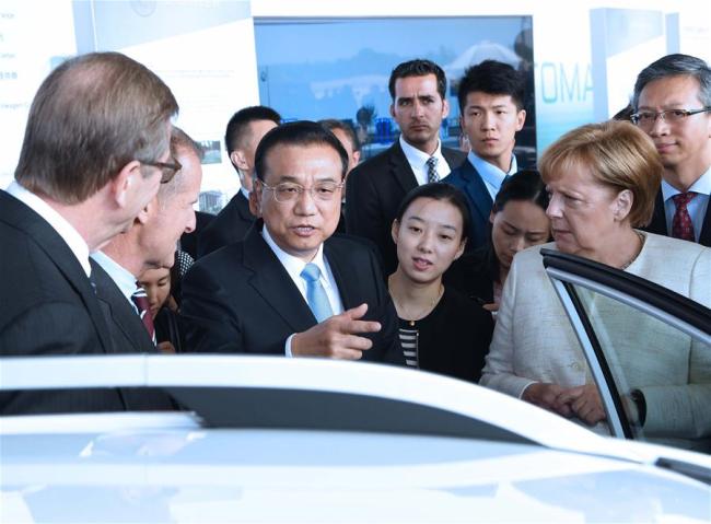 Chinese Premier Li Keqiang and German Chancellor Angela Merkel attend an autopilot cooperation exhibition between the two countries in Berlin, Germany, July 10, 2018. [Photo: Xinhua]