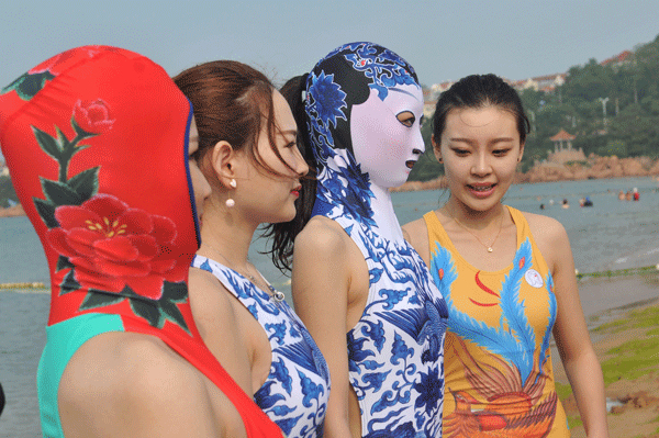 Girls wear facekini of Peking opera facial masks in Qingdao, Shandong province. [Photo by Wang Haibin/Asianewsphoto]