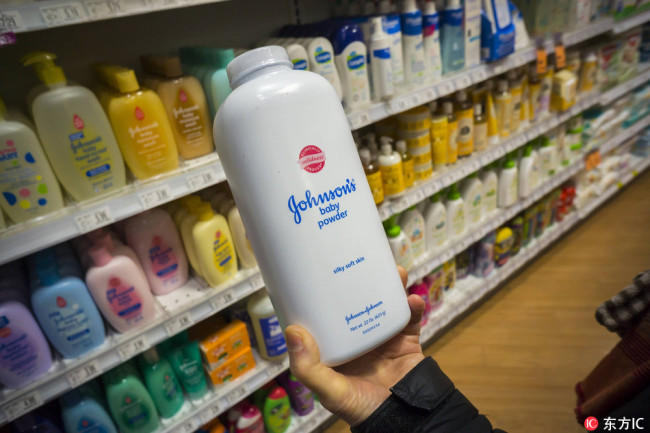 A shopper chooses a container of Johnson & Johnson brand Johnson' s Baby Powder in a drugstore in New York on Wednesday, February 24, 2016. [Photo: IC]