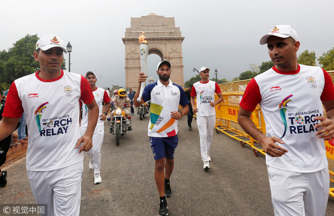 Former Indian hockey team player Sardar Singh takes part in the 2018 Asian Games torch relay in front of the India Gate in New Delhi, India, July 15, 2018. [Photo: VCG/Adnan Abidi]