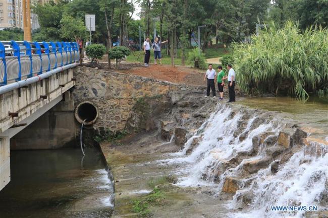 River chiefs check a sewage pipeline along the Jushan River in Xingyi City of southwest China's Guizhou Province, July 15, 2018.