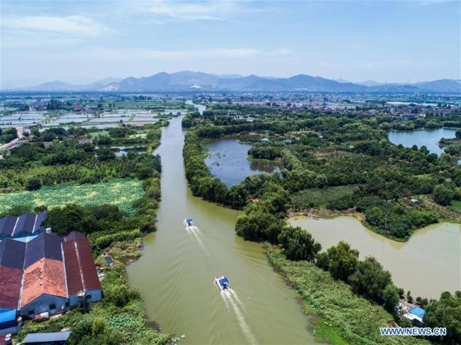 Patrol vessels of river chiefs and staff members sail in a river in Baojian Village of Donglin Township in Huzhou, east China's Zhejiang Province, July 10, 2018. 