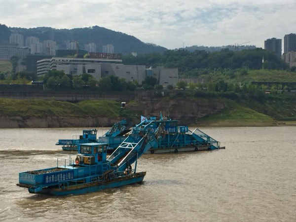 Automatic trash cleaners are moving the garbage they collect onto a trash storage boat on the Yangtze River in Wanzhou, southwest China's Chongqing on July 29, 2018. [Photo: China Plus/Yang Guang]