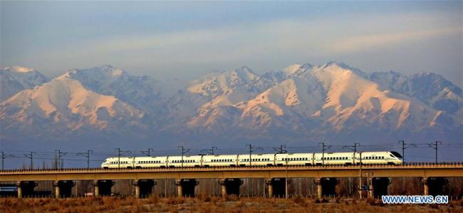 A high-speed train runs past the Tianshan Mountain(天山) in northwest China's Xinjiang Uygur Autonomous Region, Dec. 3, 2015. (Xinhua/Cai Zengle)