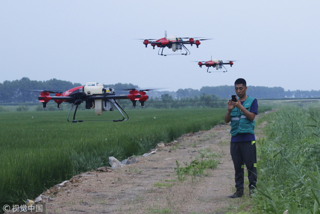A Chinese technician controls three XAG drones at the same time. [File Photo: VCG]