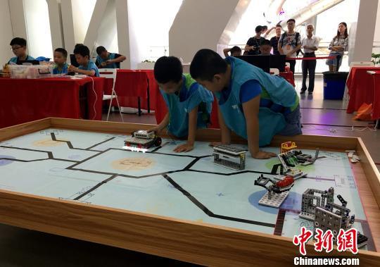 Two students cooperate together during a World Educational Robot contest on August 5. [Photo: Chinanews.com]