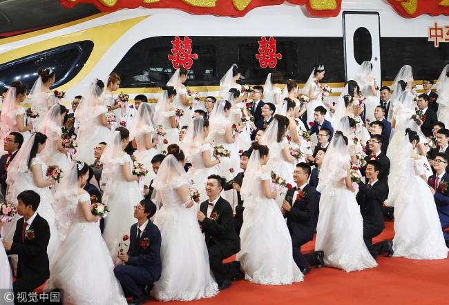 A group wedding is held at a manufacturing workshop of the Changchun Railway Vehicles in Jilin Province on August 18. [Photo: VCG]