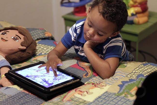 In this Oct. 21, 2011 file photo, Frankie Thevenot, 3, plays with an iPad in his bedroom at his home in Metairie, La. [Photo: AP/Gerald Herbert]