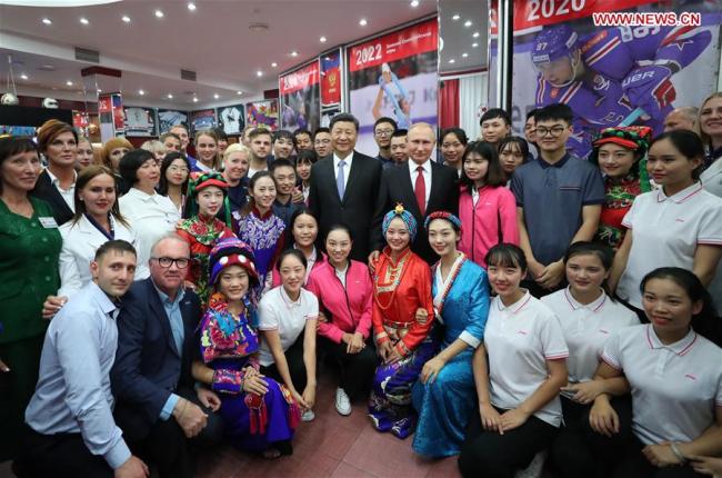Chinese President Xi Jinping and Russian President Vladimir Putin pose for photos with youths from China and Russia and faculty representatives as they visit the All-Russian Children's Center "Ocean" in Vladivostok, Russia, Sept. 12, 2018.[Photo: Xinhua]