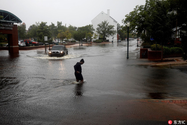 A man tries to cross the street during the heavy rain of outer bands of Hurricane Florence in New Bern, North Carolina, United States on September 13, 2018.[Photo: IC]