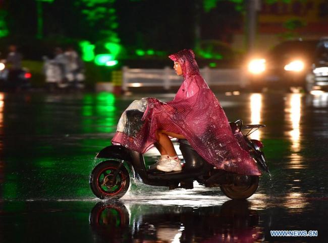 A citizen rides against storm in Yulin, south China's Guangxi Zhuang Autonomous Region, Sept. 16, 2018. Local meteorologic authority issued a red warning against typhoon on Sunday.