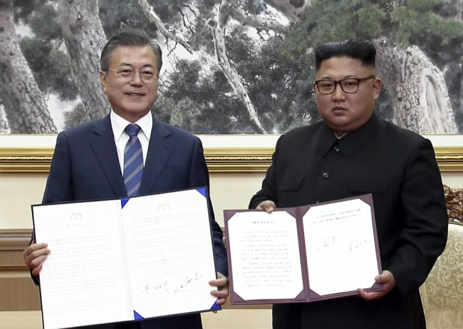 South Korean President Moon Jae-in, left, and North Korean leader Kim Jong Un pose after signing documents in Pyongyang on Sept. 19, 2018. [Photo: AP]