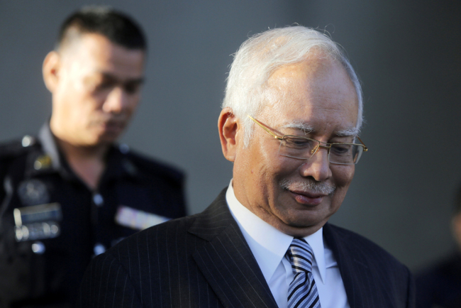Former Prime Minister Najib Razak walks out of Kuala Lumpur High Court in Kuala Lumpur, Malaysia, Friday, Aug. 10, 2018. [Photo: AP/Yam G-Jun]