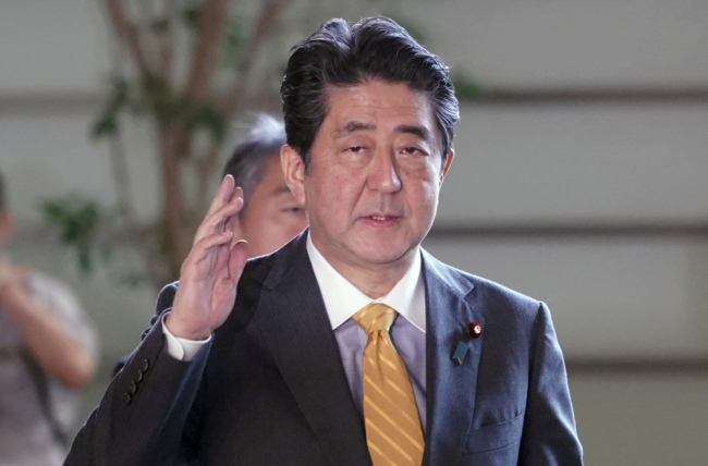 Japanese Prime Minister Shinzo Abe waves upon arrival at his official residence in Tokyo Tuesday, Sept. 18, 2018. [Photo: AP/Eugene Hoshiko, Pool]
