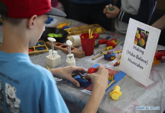 A child makes mooncake with plasticine during the Mid-Autumn Moon Family Festival event held at the Museum of Chinese in America (MOCA) in New York, the United States, Sept. 22, 2018. [Photo: Xinhua] 