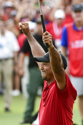 Tiger Woods celebrates after picking up his putt for par on the 18th green to win the final round of the Tour Championship golf tournament Sunday, Sept. 23, 2018, in Atlanta. [Photo: AP/John Amis]