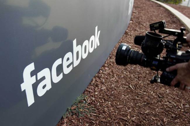 A television photographer shoots the sign outside of Facebook headquarters in Menlo Park, Calif. [File photo: AP]