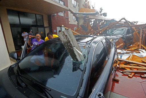 A woman checks on her vehicle as Hurricane Michael passes through, after the hotel canopy had just collapsed, in Panama City Beach, Fla., Wednesday, Oct. 10, 2018. [Photo: AP]