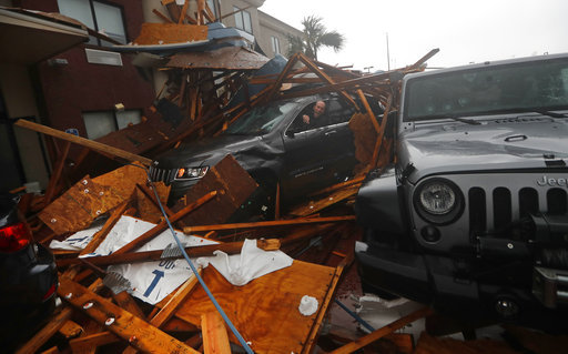A storm chaser climbs into his vehicle during the eye of Hurricane Michael to retrieve equipment after a hotel canopy collapsed in Panama City Beach, Fla., Wednesday, Oct. 10, 2018. [Photo: AP]