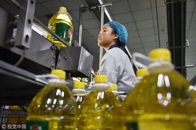 A worker monitoring a soybean oil production line at the Hopeful Grain and Oil Group factory in Sanhe, north China's Hebei Province, July 19, 2018. [Photo: VCG]