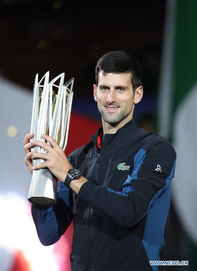 Novak Djokovic of Serbia poses with the trophy(奖杯) during the awarding ceremony of the men's singles event at 2018 ATP Shanghai Masters tennis(网球) tournament in Shanghai, east China, Oct. 14, 2018. Novak Djokovic won 2-0 in the final(决赛) and claimed the title of the event(活动). (Xinhua/Ding Ting)