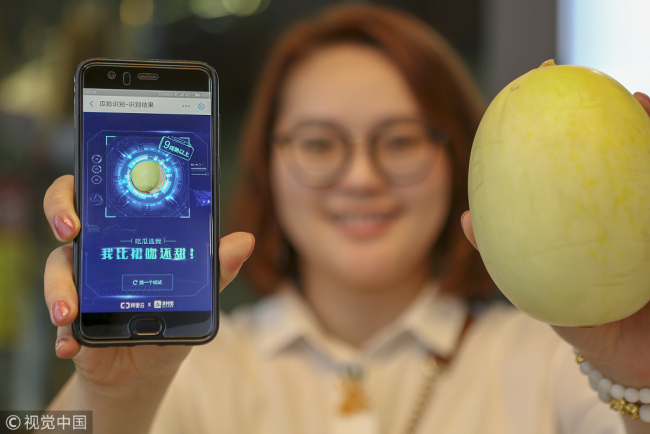 Information about the sweetness of a muskmelon is displayed on a customer's smartphone at a melon store in Haikou, the capital of south China's Hainan Province, on October 10, 2018. [Photo: VCG]