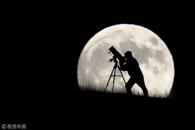An astronomer stargazes ahead of the supermoon on Sept 27, 2015 in Brighton, England. [Photo:VCG]