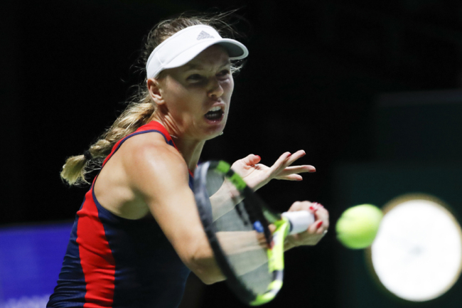Caroline Wozniacki of Denmark plays a return shot while competing against Elina Svitolina of the Ukraine during their women's singles match at the WTA tennis finals in Singapore, Thursday, Oct. 25, 2018. [Photo: AP]