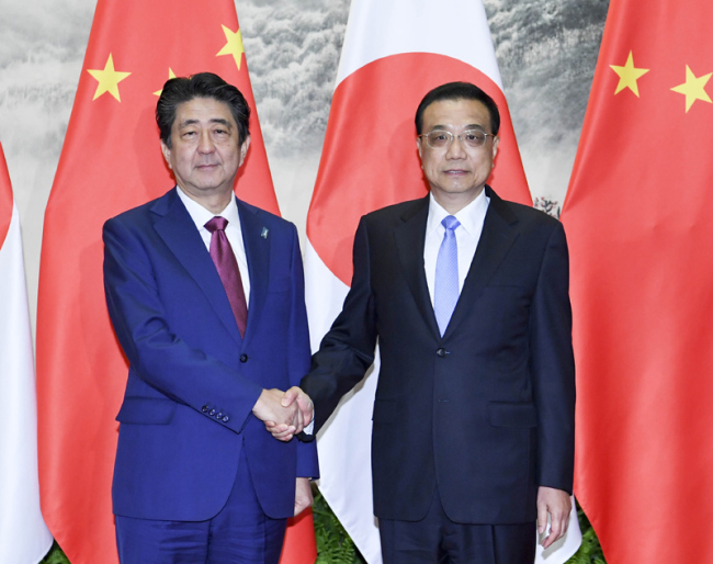 Premier Li Keqiang shakes hands with visiting Japanese Prime Minister Shinzo Abe at the Great Hall of the People in Beijing. [Photo: gov.cn]