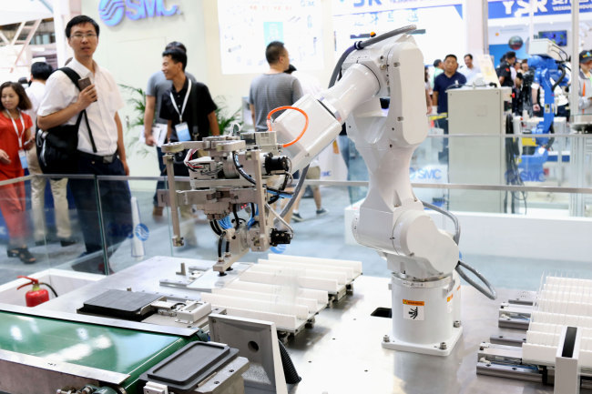 A demonstration of a robotic arm working on a smartphone assembly line at SMC China's booth at the 4th World Robot Conference in Beijing on Wednesday, August 15, 2018. [Photo: China Plus]