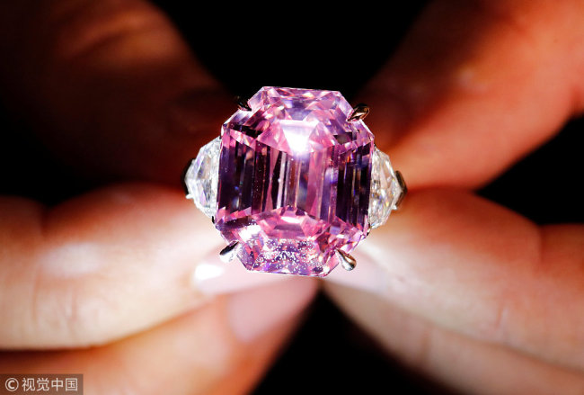 A Christie's employee displays an 18.96-carat fancy vivid pink diamond during a preview at Christie's in Geneva, Switzerland, Thursday, Nov. 8, 2018. [Photo: VCG]