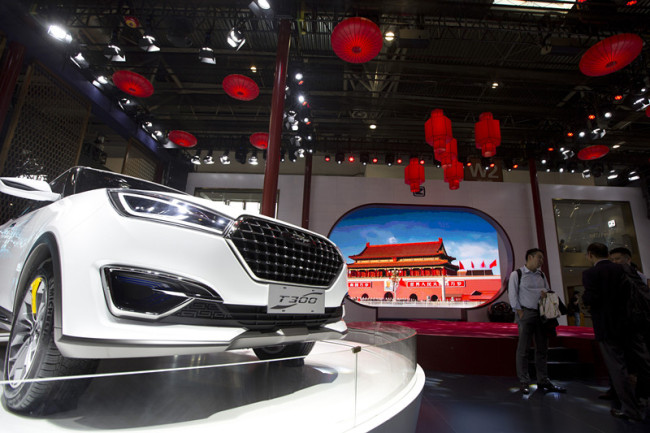 In this file photo taken Monday, April 25, 2016, visitors to Auto China 2016 stand near Zotye Auto's T300 SUV displayed in Beijing, China. [Photo: AP/Ng Han Guan]