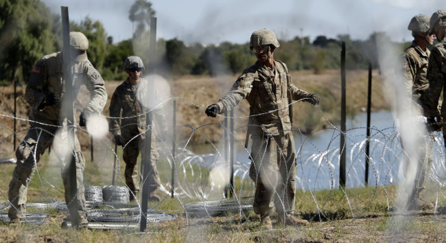 In this Nov. 16, 2018, photo, members of the U.S. military install multiple tiers of concertina wire along the banks of the Rio Grande near the Juarez-Lincoln Bridge at the U.S.-Mexico border in Laredo, Texas. [Photo: AP]
