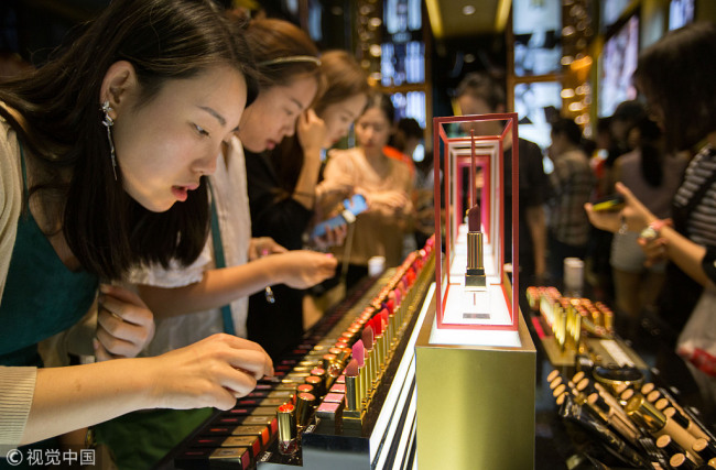 In this November 29, 2016 file photo, customers choose cosmetic products at a duty-free store in Sanya, south China’s Hainan Province. [Photo: VCG] 