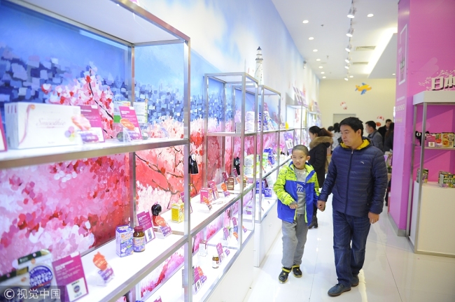 Consumers select goods at a cross-border e-commerce offline store in Tianjin. [File photo: VCG]