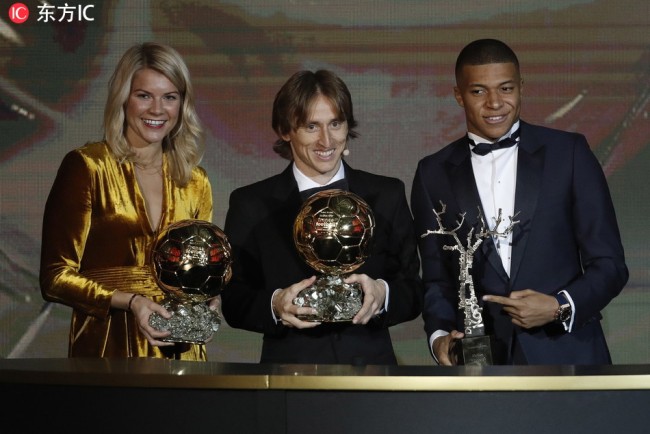 Olympique Lyonnais' Ada Hegerberg, Real Madrid's Luka Modric and Paris St Germain's Kylian Mbappe holds their 'Ballon d'Or' (Golden ball) trophies during the ceremony rewarding the best European footballer of the year in Paris, France, 03 December 2018.[Photo: IC]
