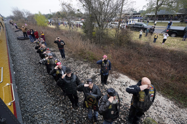People pay their respects as the train carrying the casket of former President George H.W. Bush passes Thursday, Dec. 6, 2018, along the route from Spring to College Station, Texas. [Photo: AP/David J. Phillip]