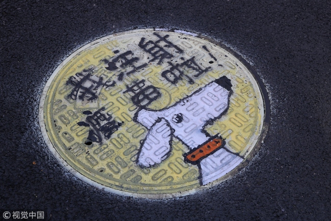 “汪星人”呼唤大家文明养犬 Beijing manhole art promotes proper dog ownership