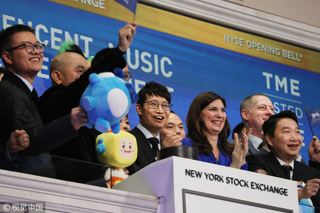 Cussion Kar Shun Pang, CEO of Tencent Music Entertainment, (center) rings the opening bell of the New York Stock Exchange (NYSE) as the Chinese music-streaming service launches its IPO on December 12, 2018 in New York City. Tencent Music priced its IPO shares late Tuesday at $13 per American depository share. [Photo: Getty Images/Spencer Platt]