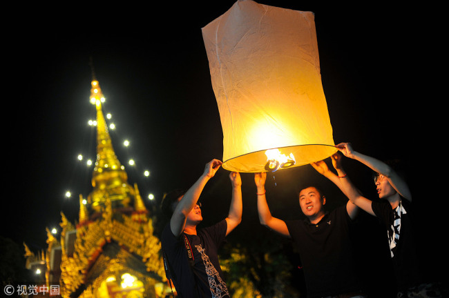 Travelers release floating lanterns during the festival of Yee Peng in Chiang Mai, Thailand on November 26, 2015. [Photo: VCG]