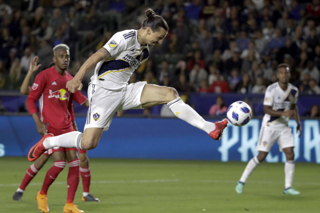 In this April 28, 2018, file photo, LA Galaxy forward Zlatan Ibrahimovic kicks the ball into the goal during the second half of an MLS soccer match against the New York Red Bulls, in Carson, Calif. The goal was later disallowed. Zlatan Ibrahimovic is returning to the Los Angeles Galaxy. A person with knowledge of the deal confirms the 37-year-old striker will play next season for the Galaxy. The person spoke on the condition of anonymity because the team had not yet formally announced it. [Photo: AP]