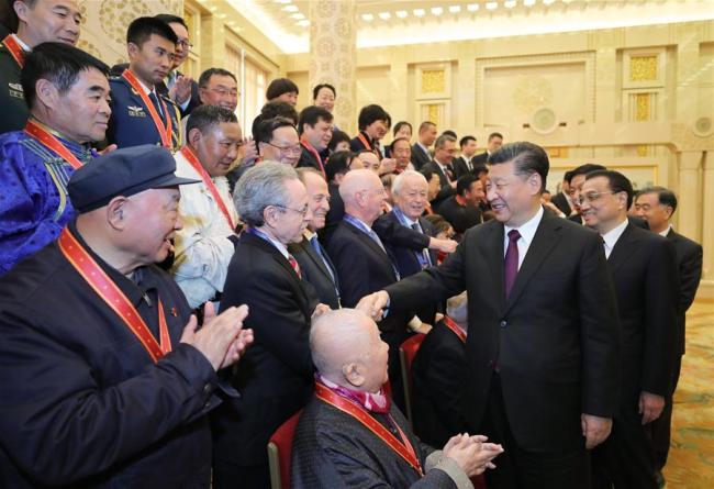 Chinese President Xi Jinping, also general secretary of the Communist Party of China (CPC) Central Committee and chairman of the Central Military Commission, and other Chinese leaders shake hands with the award recipients and their relatives after a grand gathering to celebrate the 40th anniversary of China's reform and opening-up at the Great Hall of the People in Beijing, capital of China, Dec. 18, 2018. Award recipients were presented medals for their outstanding contributions to the reform and opening-up. Xi made an important speech at the gathering. [Photo: Xinhua/Ju Peng]