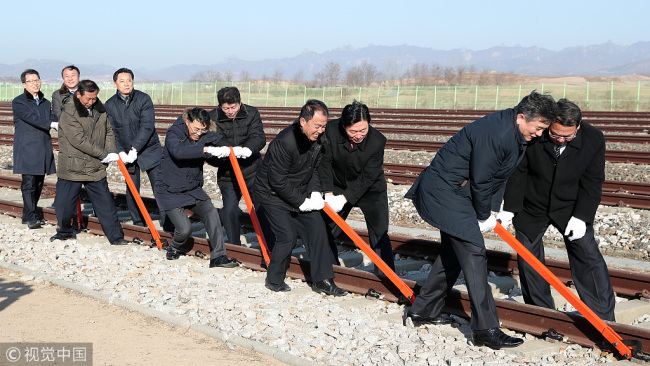 South and North Korea's officials try to connect the railroad during the ceremony for a project to modernize and connect roads and railways over the border between the Koreas at Panmun Station on December 26, 2018 in Kaesong, North Korea. [Photo: Korea Pool/Getty Images]